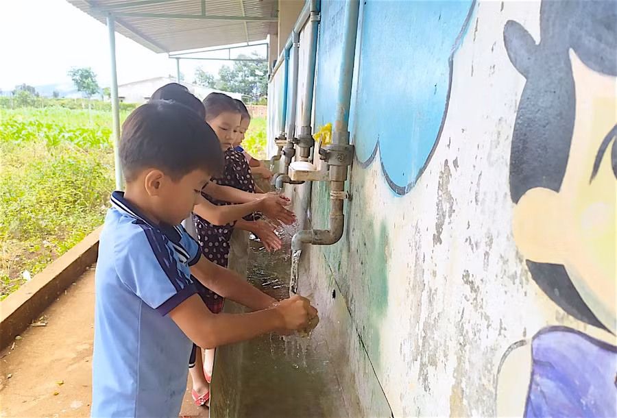 Đảm bảo nước sạch và vệ sinh trường học (GLO)- Sau 3 năm triển khai, chương trình “Mở rộng quy mô vệ sinh và nước sạch nông thôn dựa trên kết quả” vay vốn Ngân hàng Thế giới (WB) đã giúp nhiều trường học vùng khó có được các công trình vệ sinh và nước sạch đảm bảo, góp phần nâng cao chất lượng giáo dục. Hiệu quả thiết thực Cách trung tâm huyện Ia Grai khoảng 15 km, Trường Tiểu học Nguyễn Văn Trỗi (xã Ia Hrung) có 5 điểm trường làng và 1 cụm trung tâm. Từ lâu, nhà trường luôn chú trọng đến công tác giữ gìn vệ sinh để bảo vệ sức khỏe học sinh. Đặc biệt, năm 2018, nhà trường tham gia chương trình “Mở rộng quy mô vệ sinh và nước sạch nông thôn dựa trên kết quả” vay vốn WB ở tiểu hợp phần “Truyền thông, giáo dục hành vi hợp vệ sinh”. Từ đó, nhận thức và hành vi của giáo viên, học sinh đã có những thay đổi tích cực. Vừa qua, nhà trường được huyện đầu tư lắp đặt hệ thống lọc nước uống với kinh phí hơn 130 triệu đồng; đồng thời chủ động trích 70 triệu đồng từ nguồn chi thường xuyên để khoan giếng nhằm chủ động nguồn nước sạch phục vụ sinh hoạt. Cô Bùi Thị Hà-Hiệu trưởng nhà trường-cho biết: Hiện nay, hệ thống nhà vệ sinh, nước sạch cho giáo viên, học sinh tương đối đầy đủ ở cả điểm chính và điểm lẻ. Để đảm bảo vệ sinh môi trường, nhà trường thường xuyên sửa chữa, tu bổ các nhà vệ sinh bị hư hỏng; thường xuyên vệ sinh hệ thống chậu rửa tay và cung cấp đầy đủ xà phòng, khăn, giấy vệ sinh…, hướng dẫn học sinh cách giữ gìn vệ sinh cá nhân, rửa tay bằng xà phòng đúng cách. Riêng tại 3 điểm trường chưa có hệ thống bồn rửa tay, nhà trường đã làm ống dẫn nước lắp vòi rửa và khay đựng xà phòng bên cạnh nhà vệ sinh cho học sinh sử dụng. Ngoài ra, nhà trường còn tích cực tuyên truyền nhằm nâng cao ý thức trách nhiệm vệ sinh môi trường, sử dụng, bảo quản công trình nhà vệ sinh; tổ chức cho học sinh tham gia lao động, dọn dẹp vệ sinh trường, lớp hàng tuần và trực nhật, dọn dẹp vệ sinh hàng ngày theo quy định; tăng cường giáo dục hành vi hợp vệ sinh bằng áp phích, vẽ trang trí trên tường và thông qua các bài hát, điệu nhảy tập thể, hoạt động ngoại khóa. “Sau khi được đầu tư, các công trình đã phát huy tác dụng, giúp học sinh có địa điểm vệ sinh kiên cố, sạch sẽ; góp phần đảm bảo các điều kiện phục vụ cho hoạt động sinh hoạt và giáo dục của nhà trường. Đến nay, 100% học sinh đã hình thành thói quen giữ gìn vệ sinh cá nhân và vệ sinh chung, biết rửa tay bằng xà phòng đúng cách, theo 6 bước”-cô Hà chia sẻ. Năm nay, Trường Mẫu giáo Măng Non (xã Thành An, thị xã An Khê) cũng được cấp kinh phí từ chương trình “Mở rộng quy mô vệ sinh và nước sạch nông thôn dựa trên kết quả” để đầu tư nâng cấp nhà vệ sinh cho giáo viên và học sinh. Công trình đang được triển khai và dự kiến giữa tháng 12 này sẽ hoàn thành. Hiệu trưởng Trần Thị Thu Hằng phấn khởi nói: “Công trình nhà vệ sinh này cùng với dãy phòng học mới vừa được đầu tư xây dựng sẽ tạo nên diện mạo khang trang, sạch đẹp cho nhà trường; giúp chúng tôi có điều kiện tốt hơn để chăm sóc, giáo dục trẻ và tạo niềm tin nơi phụ huynh khi gửi gắm con em học tại trường”. Gắn với chuyên đề “Trường xanh-sạch-đẹp-an toàn” Gia Lai là 1 trong 21 tỉnh trên cả nước được chọn triển khai chương trình “Mở rộng quy mô vệ sinh và nước sạch nông thôn dựa trên kết quả” vay vốn WB. Trong số 3 hợp phần của chương trình, Sở Giáo dục và Đào tạo (GD-ĐT) được giao nhiệm vụ triển khai hợp phần nước sạch và vệ sinh tại một số trường học ở vùng nông thôn còn nhiều khó khăn, bắt đầu từ năm 2018. Giám đốc Sở GD-ĐT Lê Duy Định cho biết: Bên cạnh việc đầu tư xây dựng mới và sửa chữa, nâng cấp, hoạt động cốt lõi của chương trình là truyền thông thay đổi hành vi hợp vệ sinh cho học sinh. Xuất phát từ thực trạng các trường đứng chân ở vùng nông thôn, điều kiện kinh tế-xã hội còn khó khăn, phần đông học sinh là người dân tộc thiểu số… thì việc thay đổi hành vi của học sinh phải bắt đầu từ nếp nghĩ, tư duy và năng lực truyền thông, giáo dục hành vi hợp vệ sinh của thầy-cô giáo. Trên cơ sở tập huấn về kiến thức, kỹ năng hàng năm của Sở GD-ĐT, các trường học xây dựng kế hoạch và tổ chức các hoạt động truyền thông thường xuyên trong suốt năm học. Hiệu trưởng các trường cam kết thực hiện truyền thông, đảm bảo vệ sinh cảnh quan môi trường, thực hiện các giải pháp đảm bảo nhà vệ sinh cho học sinh đạt các tiêu chuẩn mà chương trình đề ra; cung cấp xà phòng rửa tay cũng như có chỗ rửa tay bằng nước sạch và giáo dục học sinh kỹ năng rửa tay đúng cách theo quy định của Bộ Y tế. Cũng theo Giám đốc Sở GD-ĐT, để tăng cường hơn nữa việc đảm bảo nước sạch và vệ sinh trường học trên địa bàn tỉnh, cuối tháng 11 vừa qua, Sở đã có văn bản đề nghị phòng GD-ĐT chỉ đạo các trường học liên quan gắn việc triển khai thực hiện chương trình “Mở rộng quy mô vệ sinh và nước sạch nông thôn dựa trên kết quả” với chuyên đề thi đua “Trường xanh-sạch-đẹp-an toàn”; thực hiện nghiêm công tác kiểm tra, đôn đốc, giám sát, tư vấn và hỗ trợ nhằm giúp các trường đạt cũng như tiếp tục duy trì các tiêu chí trong thời gian đến. HỒNG THI Từ năm 2018, Sở GD-ĐT được giao nhiệm vụ triển khai hợp phần nước sạch và vệ sinh tại một số trường học ở vùng nông thôn còn nhiều khó khăn. Qua 3 năm thực hiện, chương trình đã đầu tư sửa chữa và xây mới 59 công trình vệ sinh tại các trường học, riêng năm 2020 là 28 công trình. Hầu hết học sinh Trường Tiểu học Nguyễn Văn Trỗi (xã Ia Hrung, huyện Ia Grai) đã ý thức việc rửa tay thường xuyên, đúng cách. Ảnh: Hồng Thi