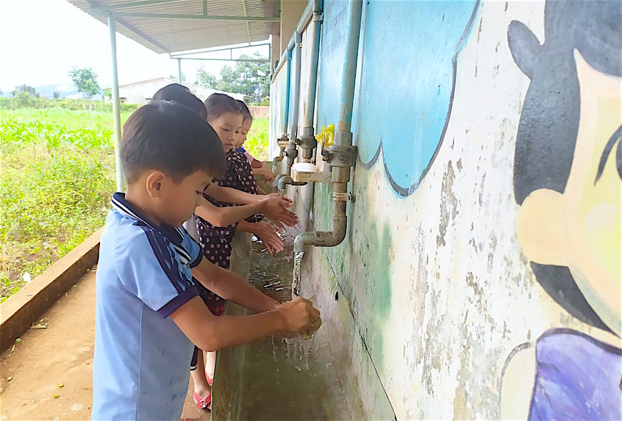 Đảm bảo nước sạch và vệ sinh trường học (GLO)- Sau 3 năm triển khai, chương trình “Mở rộng quy mô vệ sinh và nước sạch nông thôn dựa trên kết quả” vay vốn Ngân hàng Thế giới (WB) đã giúp nhiều trường học vùng khó có được các công trình vệ sinh và nước sạch đảm bảo, góp phần nâng cao chất lượng giáo dục. Hiệu quả thiết thực Cách trung tâm huyện Ia Grai khoảng 15 km, Trường Tiểu học Nguyễn Văn Trỗi (xã Ia Hrung) có 5 điểm trường làng và 1 cụm trung tâm. Từ lâu, nhà trường luôn chú trọng đến công tác giữ gìn vệ sinh để bảo vệ sức khỏe học sinh. Đặc biệt, năm 2018, nhà trường tham gia chương trình “Mở rộng quy mô vệ sinh và nước sạch nông thôn dựa trên kết quả” vay vốn WB ở tiểu hợp phần “Truyền thông, giáo dục hành vi hợp vệ sinh”. Từ đó, nhận thức và hành vi của giáo viên, học sinh đã có những thay đổi tích cực. Vừa qua, nhà trường được huyện đầu tư lắp đặt hệ thống lọc nước uống với kinh phí hơn 130 triệu đồng; đồng thời chủ động trích 70 triệu đồng từ nguồn chi thường xuyên để khoan giếng nhằm chủ động nguồn nước sạch phục vụ sinh hoạt. Cô Bùi Thị Hà-Hiệu trưởng nhà trường-cho biết: Hiện nay, hệ thống nhà vệ sinh, nước sạch cho giáo viên, học sinh tương đối đầy đủ ở cả điểm chính và điểm lẻ. Để đảm bảo vệ sinh môi trường, nhà trường thường xuyên sửa chữa, tu bổ các nhà vệ sinh bị hư hỏng; thường xuyên vệ sinh hệ thống chậu rửa tay và cung cấp đầy đủ xà phòng, khăn, giấy vệ sinh…, hướng dẫn học sinh cách giữ gìn vệ sinh cá nhân, rửa tay bằng xà phòng đúng cách. Riêng tại 3 điểm trường chưa có hệ thống bồn rửa tay, nhà trường đã làm ống dẫn nước lắp vòi rửa và khay đựng xà phòng bên cạnh nhà vệ sinh cho học sinh sử dụng. Ngoài ra, nhà trường còn tích cực tuyên truyền nhằm nâng cao ý thức trách nhiệm vệ sinh môi trường, sử dụng, bảo quản công trình nhà vệ sinh; tổ chức cho học sinh tham gia lao động, dọn dẹp vệ sinh trường, lớp hàng tuần và trực nhật, dọn dẹp vệ sinh hàng ngày theo quy định; tăng cường giáo dục hành vi hợp vệ sinh bằng áp phích, vẽ trang trí trên tường và thông qua các bài hát, điệu nhảy tập thể, hoạt động ngoại khóa. “Sau khi được đầu tư, các công trình đã phát huy tác dụng, giúp học sinh có địa điểm vệ sinh kiên cố, sạch sẽ; góp phần đảm bảo các điều kiện phục vụ cho hoạt động sinh hoạt và giáo dục của nhà trường. Đến nay, 100% học sinh đã hình thành thói quen giữ gìn vệ sinh cá nhân và vệ sinh chung, biết rửa tay bằng xà phòng đúng cách, theo 6 bước”-cô Hà chia sẻ. Năm nay, Trường Mẫu giáo Măng Non (xã Thành An, thị xã An Khê) cũng được cấp kinh phí từ chương trình “Mở rộng quy mô vệ sinh và nước sạch nông thôn dựa trên kết quả” để đầu tư nâng cấp nhà vệ sinh cho giáo viên và học sinh. Công trình đang được triển khai và dự kiến giữa tháng 12 này sẽ hoàn thành. Hiệu trưởng Trần Thị Thu Hằng phấn khởi nói: “Công trình nhà vệ sinh này cùng với dãy phòng học mới vừa được đầu tư xây dựng sẽ tạo nên diện mạo khang trang, sạch đẹp cho nhà trường; giúp chúng tôi có điều kiện tốt hơn để chăm sóc, giáo dục trẻ và tạo niềm tin nơi phụ huynh khi gửi gắm con em học tại trường”. Gắn với chuyên đề “Trường xanh-sạch-đẹp-an toàn” Gia Lai là 1 trong 21 tỉnh trên cả nước được chọn triển khai chương trình “Mở rộng quy mô vệ sinh và nước sạch nông thôn dựa trên kết quả” vay vốn WB. Trong số 3 hợp phần của chương trình, Sở Giáo dục và Đào tạo (GD-ĐT) được giao nhiệm vụ triển khai hợp phần nước sạch và vệ sinh tại một số trường học ở vùng nông thôn còn nhiều khó khăn, bắt đầu từ năm 2018. Giám đốc Sở GD-ĐT Lê Duy Định cho biết: Bên cạnh việc đầu tư xây dựng mới và sửa chữa, nâng cấp, hoạt động cốt lõi của chương trình là truyền thông thay đổi hành vi hợp vệ sinh cho học sinh. Xuất phát từ thực trạng các trường đứng chân ở vùng nông thôn, điều kiện kinh tế-xã hội còn khó khăn, phần đông học sinh là người dân tộc thiểu số… thì việc thay đổi hành vi của học sinh phải bắt đầu từ nếp nghĩ, tư duy và năng lực truyền thông, giáo dục hành vi hợp vệ sinh của thầy-cô giáo. Trên cơ sở tập huấn về kiến thức, kỹ năng hàng năm của Sở GD-ĐT, các trường học xây dựng kế hoạch và tổ chức các hoạt động truyền thông thường xuyên trong suốt năm học. Hiệu trưởng các trường cam kết thực hiện truyền thông, đảm bảo vệ sinh cảnh quan môi trường, thực hiện các giải pháp đảm bảo nhà vệ sinh cho học sinh đạt các tiêu chuẩn mà chương trình đề ra; cung cấp xà phòng rửa tay cũng như có chỗ rửa tay bằng nước sạch và giáo dục học sinh kỹ năng rửa tay đúng cách theo quy định của Bộ Y tế. Cũng theo Giám đốc Sở GD-ĐT, để tăng cường hơn nữa việc đảm bảo nước sạch và vệ sinh trường học trên địa bàn tỉnh, cuối tháng 11 vừa qua, Sở đã có văn bản đề nghị phòng GD-ĐT chỉ đạo các trường học liên quan gắn việc triển khai thực hiện chương trình “Mở rộng quy mô vệ sinh và nước sạch nông thôn dựa trên kết quả” với chuyên đề thi đua “Trường xanh-sạch-đẹp-an toàn”; thực hiện nghiêm công tác kiểm tra, đôn đốc, giám sát, tư vấn và hỗ trợ nhằm giúp các trường đạt cũng như tiếp tục duy trì các tiêu chí trong thời gian đến. HỒNG THI Từ năm 2018, Sở GD-ĐT được giao nhiệm vụ triển khai hợp phần nước sạch và vệ sinh tại một số trường học ở vùng nông thôn còn nhiều khó khăn. Qua 3 năm thực hiện, chương trình đã đầu tư sửa chữa và xây mới 59 công trình vệ sinh tại các trường học, riêng năm 2020 là 28 công trình. Hầu hết học sinh Trường Tiểu học Nguyễn Văn Trỗi (xã Ia Hrung, huyện Ia Grai) đã ý thức việc rửa tay thường xuyên, đúng cách. Ảnh: Hồng Thi