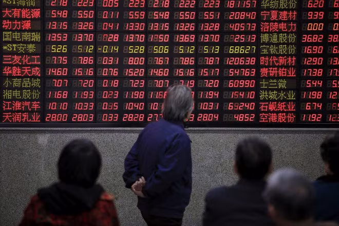 Các nhà đầu tư theo dõi thông tin chứng khoán tại Thượng Hải, Trung Quốc - Ảnh: Reuters