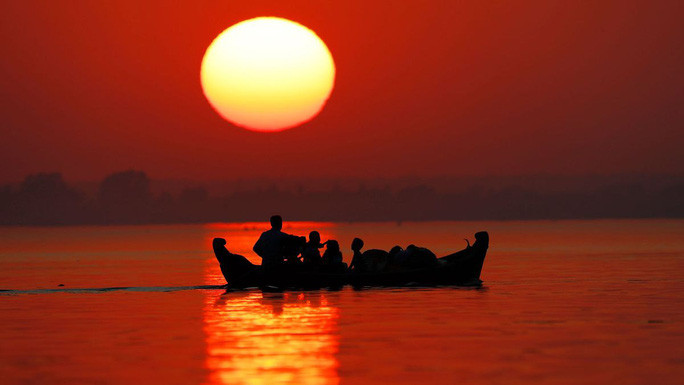  Người dân băng qua sông Irrawaddy trong buổi hoàng hôn cuối cùng của năm 2020 ở TP Mandalay - Myanmar. Ảnh: AP