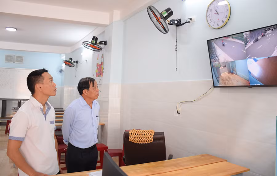  Ông Bùi Xuân Đồng (bên phải; Tổ trưởng tổ 7, phường Hội Thương, TP. Pleiku) cùng người dân xem hình ảnh trích xuất từ camera giám sát an ninh trật tự. Ảnh: Phương Duyên