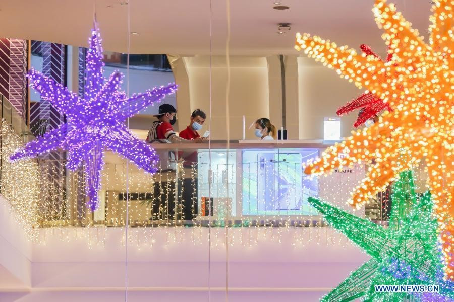 Đeo khẩu trang và tấm che mặt phòng ngừa COVID-19 tại một trung tâm mua sắm ở Manila, Philippines. Ảnh: Xinhua