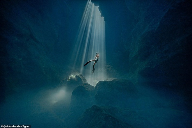 Bức ảnh đáng kinh ngạc này được chụp bên trong một hang động ở Menorca bởi nhiếp ảnh gia Victor de Valles Ibanez, người Tây Ban Nha. Tác giả giải thích về quá trình chụp bức ảnh này: “Để đến hang động, bạn cần phải đi bộ sát vách đá cao, giữa những tảng đá lớn. Sau đó bạn lặn 30 mét bên trong hang động để chờ đợi các tia nắng chiếu vào”. Bức ảnh đáng kinh ngạc này được chụp bên trong một hang động ở Menorca bởi nhiếp ảnh gia Victor de Valles Ibanez, người Tây Ban Nha. Tác giả giải thích về quá trình chụp bức ảnh này: “Để đến hang động, bạn cần phải đi bộ sát vách đá cao, giữa những tảng đá lớn. Sau đó bạn lặn 30 mét bên trong hang động để chờ đợi các tia nắng chiếu vào”.