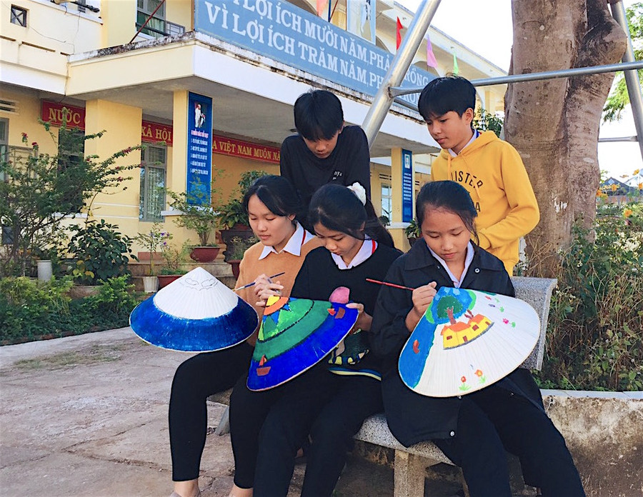 Học sinh Trường Tiểu học và THCS Lê Văn Tám (xã Trà Đa, TP. Pleiku) chăm chú vẽ tranh trên nón trong giờ ra chơi. Ảnh: Mộc Trà