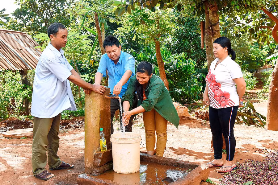 7.Bí thư chi bộ Kpă Biêk (bên trái) tuyên truyền bà con sử dụng nước sạch trong sinh hoạt phải tiết kiệm. 