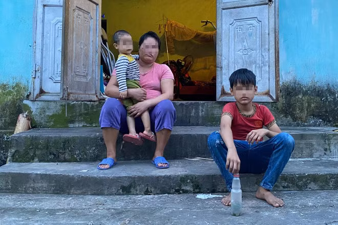 Ba mẹ con H. ngồi trước ngôi nhà tình thương do xã vận động xây dựng ẢNH: LAM NGỌC