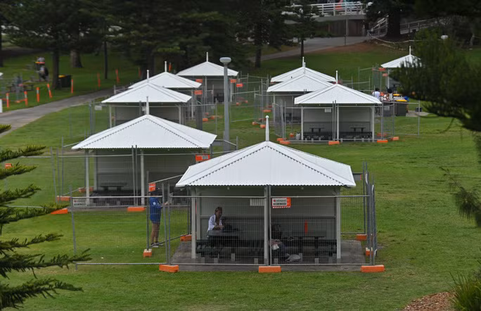 Các túp lều có bàn ăn ngoài trời được rào lại để đề phòng dịch Covid-19 lây lan vào đêm giao thừa tại bãi biển Bronte, TP Sydney - Úc. Ảnh: The Sydney Morning Herald