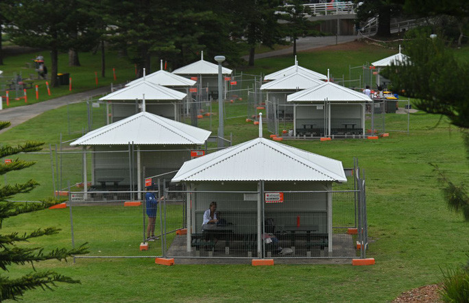 Các túp lều có bàn ăn ngoài trời được rào lại để đề phòng dịch Covid-19 lây lan vào đêm giao thừa tại bãi biển Bronte, TP Sydney - Úc. Ảnh: The Sydney Morning Herald