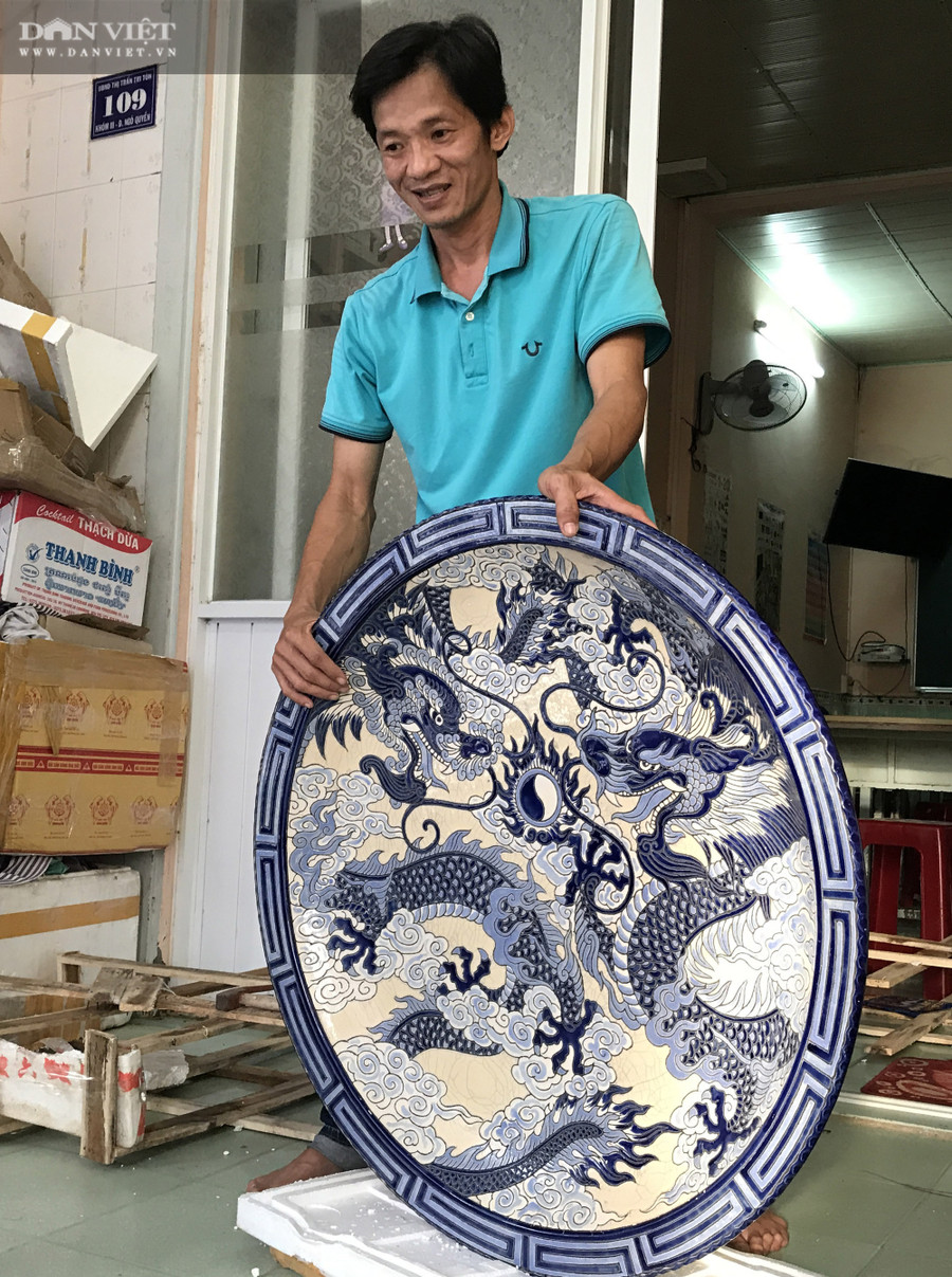  Thầy giáo Nam đang bóc một chiếc đĩa gốm có kích thước khủng được cất giữ trong kho. Ảnh: M.A.