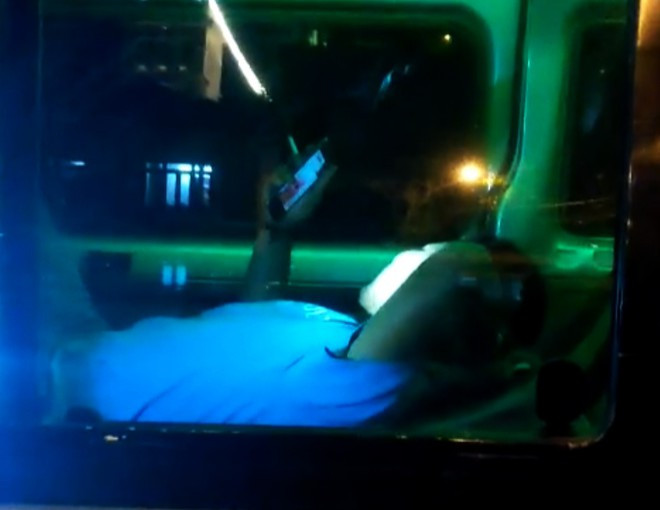 Nằm trong xe, tài xế ung dung hút thuốc, lướt điện thoại ẢNH: G.B