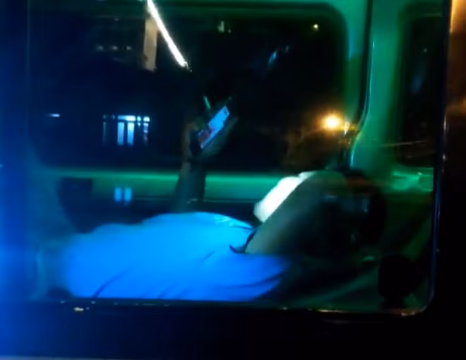 Nằm trong xe, tài xế ung dung hút thuốc, lướt điện thoại ẢNH: G.B