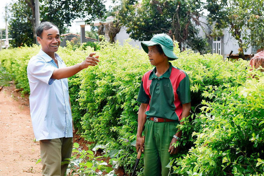 6.Ông Kpă Biêk (bên trái) vận động bà con trong làng dọn dẹp vệ sinh môi trường, làm hàng rào xanh, xây dựng đời sống văn hóa mới.