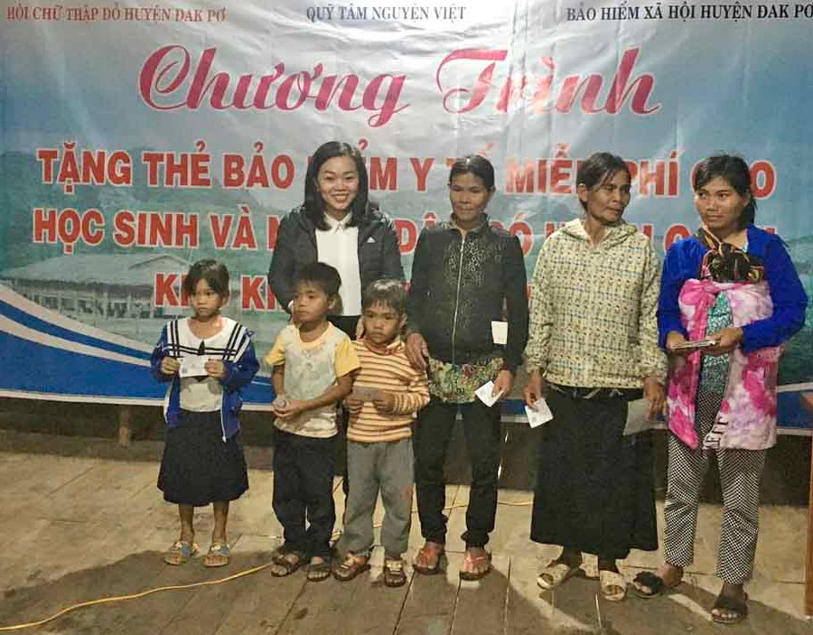 Đại diện ban tổ chức trao tặng thẻ BHYT cho bà con. Ảnh: Như Nguyện 