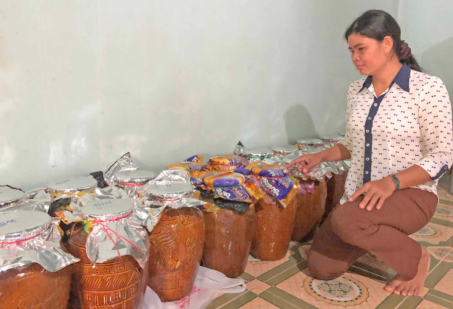 Chị Ksor H’Ben (buôn Biah A) cẩn thận kiểm tra từng ghè rượu nơi góc nhà. Ảnh: Anh Huy