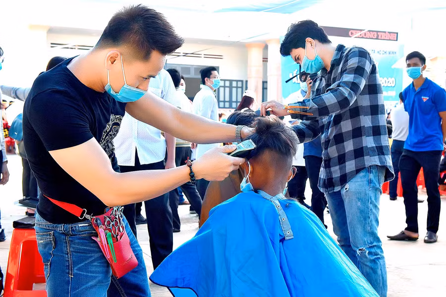 Ảnh 9: Các em nhỏ được đoàn công tác cắt tóc miễn phí.