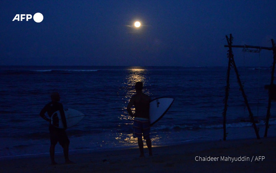 Người lướt sóng đứng ngắm nhìn cảnh tượng trăng rằm tuyệt đẹp trên biển tại bãi biển Lhoknga, tỉnh Aceh, Indonesia. Ảnh: AFP Người lướt sóng đứng ngắm nhìn cảnh tượng trăng rằm tuyệt đẹp trên biển tại bãi biển Lhoknga, tỉnh Aceh, Indonesia. Ảnh: AFP