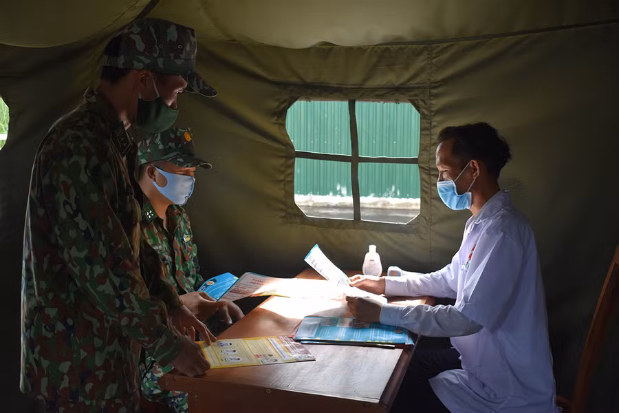 Cán bộ Đồn Biên phòng Cửa khẩu Quốc tế Lệ Thanh trao đổi tình hình phòng-chống dịch với nhân viên y tế. Ảnh: Duy Lê