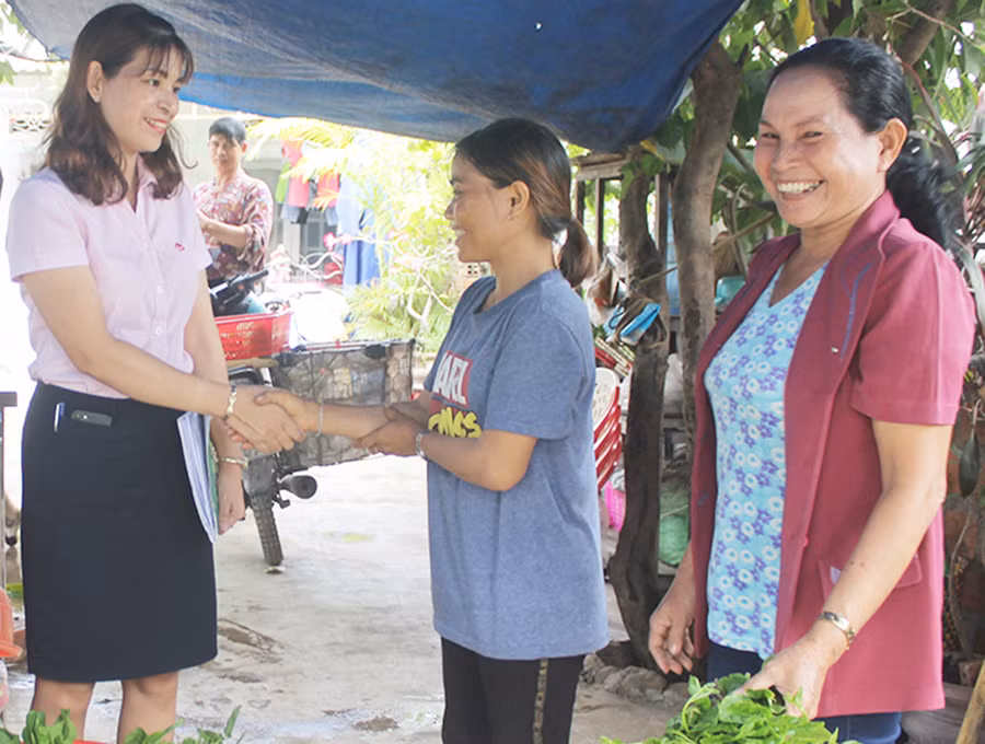 Cán bộ Phòng Giao dịch Ngân hàng Chính sách Xã hội thị xã Ayun Pa trao đổi tình hình sử dụng vốn vay của chị Ksor H'Chiêu (ở giữa). Ảnh: Sơn Ca