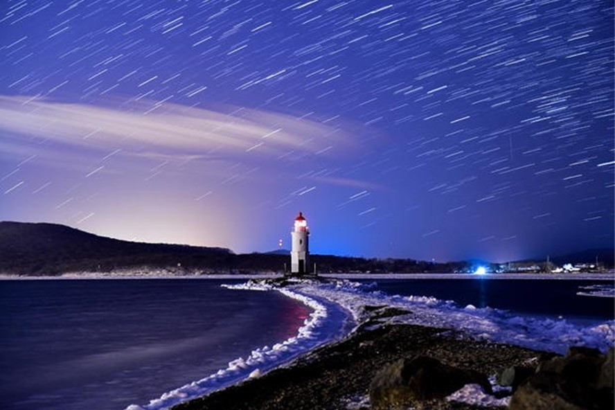 Mưa sao băng Geminids khi đạt cực điểm trên bầu trời đêm trên ngọn hải đăng Tokarevsky ở mũi Egersheld trên đảo Russky ở biển Nhật Bản vào ngày 13 tháng 12 năm 2017. Ảnh: Getty Images. Mưa sao băng Geminids khi đạt cực điểm trên bầu trời đêm trên ngọn hải đăng Tokarevsky ở mũi Egersheld trên đảo Russky ở biển Nhật Bản vào ngày 13 tháng 12 năm 2017. Ảnh: Getty Images.