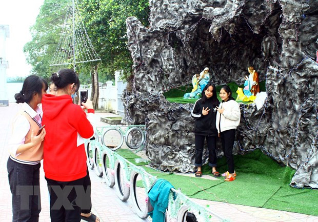 Các em nhỏ hào hứng, tạo dáng chụp ảnh tại hang đá. (Ảnh: Tá Chuyên/TTXVN)