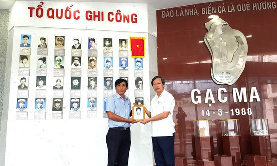 Thầy Ngô Văn Minh (bên phải) trao di ảnh quý cho Ban quản lý Khu tưởng niệm chiến sĩ Gạc Ma