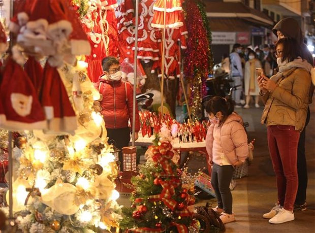  Dù trời rét đậm nhưng vẫn đông người dân đi mua sắm đồ Noel trên phố Hàng Lược. (Ảnh: Hoàng Hiếu/TTXVN)