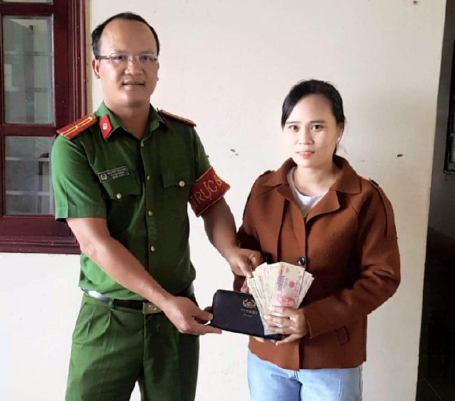 Cán bộ Công an huyện Phú Thiện trao lại chiếc ví cho chị Đỗ Như Ý. Ảnh: Thúy Trinh Trung tá Phan Thanh Cường (bìa phải) giao chiếc ví cho Công an phường Hoa Lư trả lại cho người bị mất