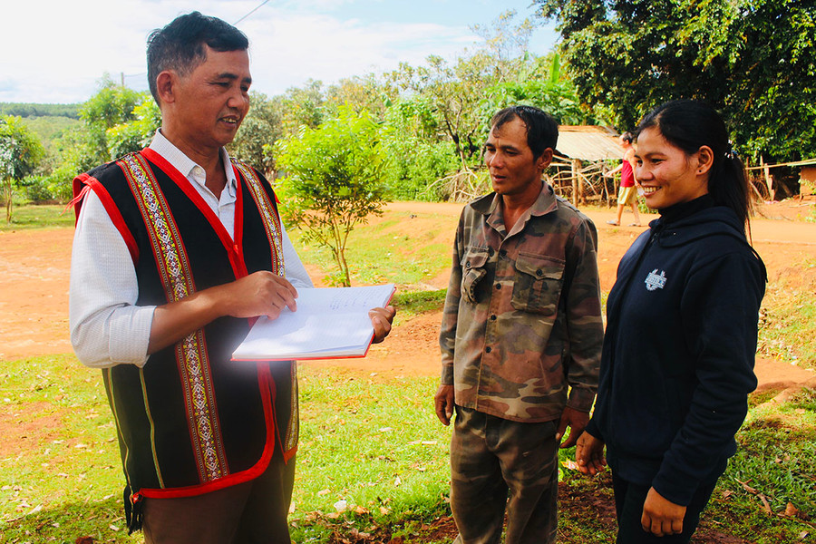  Ông Rơ Châm Nghít (bìa trái) tuyên truyền nghị quyết của Đảng cho người dân. Ảnh: Thủy Bình