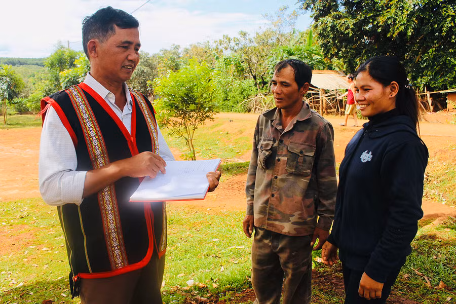  Ông Rơ Châm Nghít (bìa trái) tuyên truyền nghị quyết của Đảng cho người dân. Ảnh: Thủy Bình
