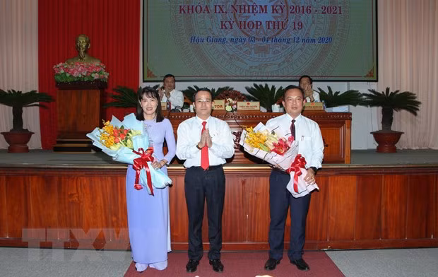 Ông Trần Văn Huyến, Phó Bí thư Thường trực Tỉnh ủy, Chủ tịch Hội đồng Nhân dân tỉnh Hậu Giang tặng hoa chúc mừng bà Hồ Thu Ánh và ông Nguyễn Văn Hòa. (Ảnh: Hồng Thái/TTXVN)