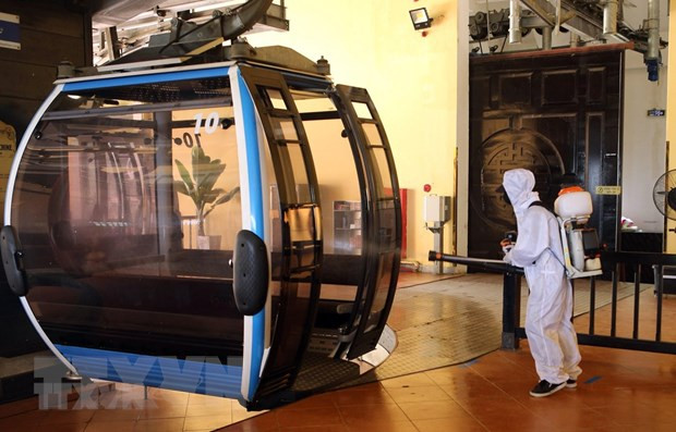 Phun thuốc khử trùng cáp treo tại Khu du lịch Bà Nà Hills. (Ảnh: Trần Lê Lâm/TTXVN)