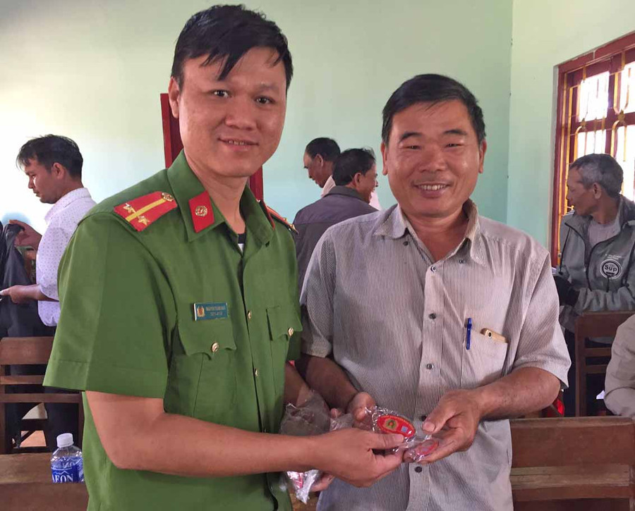 Công an xã Ia Băng (huyện Đak Đoa) trao móc khóa tận tay cho các hộ dân (ảnh đơn vị cung cấp). 