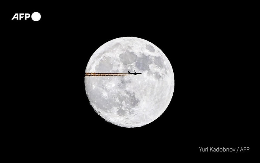 Máy bay bay ngang qua hình ảnh mặt trăng trong ngày trăng rằm ở Mátxcơva, Nga. Ảnh: AFP Máy bay bay ngang qua hình ảnh mặt trăng trong ngày trăng rằm ở Mátxcơva, Nga. Ảnh: AFP