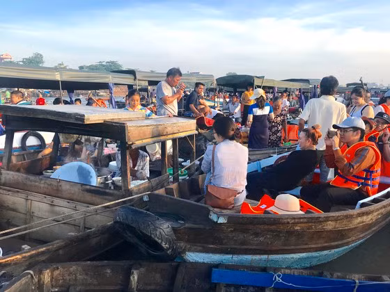 Du khách bên ghe bán đồ ăn ở chợ nổi Cái Răng (Cần Thơ)