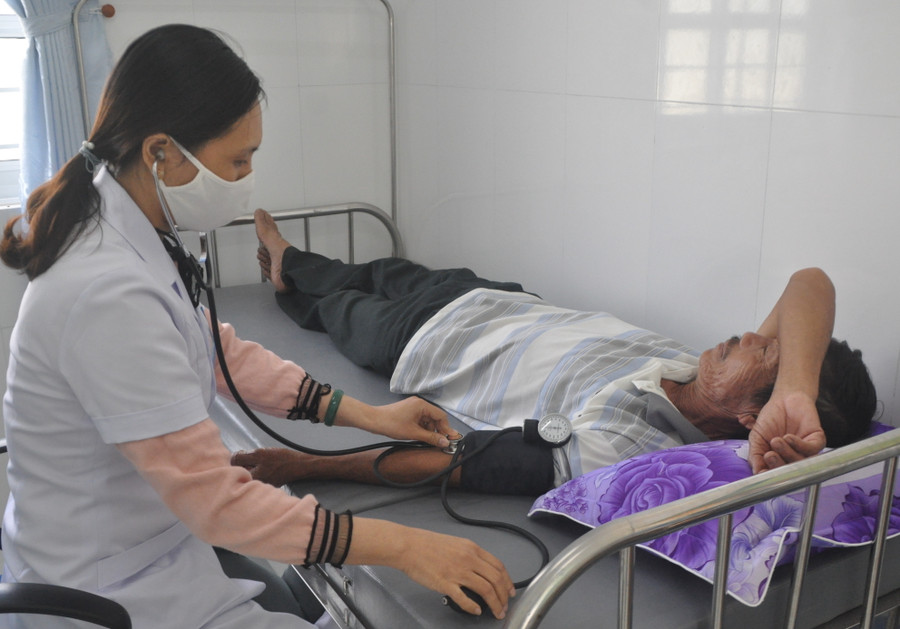 Bác sĩ Nguyễn Thị Thuận-Trạm trưởng Trạm Y tế xã Tân An (huyện Đak Pơ) khám bệnh cho bệnh nhân Nguyễn Đình Cang. Ảnh: Nguyễn Tú