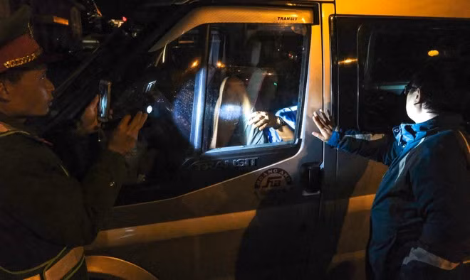 Dù công an phía ngoài liên tục kêu cửa nhưng tài xế này vẫn nằm trong xe lướt điện thoại! ẢNH: G.B