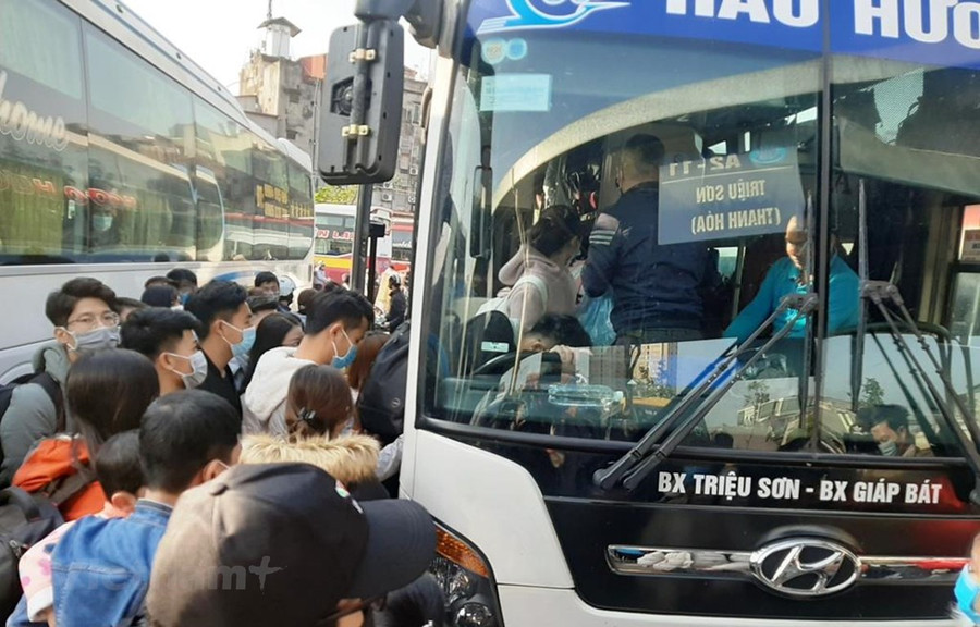 Hành khách chen chân lên xe về quê dịp nghỉ Tết Dương lịch 2021. (Ảnh: Việt Hùng/Vietnam+) Hành khách chen chân lên xe về quê dịp nghỉ Tết Dương lịch 2021. (Ảnh: Việt Hùng/Vietnam+)