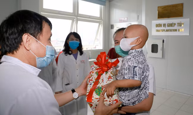 GS-TS Phạm Như Hiệp - Giám đốc Bệnh viện Trung ương Huế tặng quà cho cháu bé vừa được ghép tủy thành công.