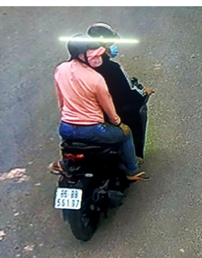 Sau khi trộm điện thoại, người phụ nữ áo hồng lên xe máy do người đàn ông chờ sẵn phía ngoài rồi tẩu thoát