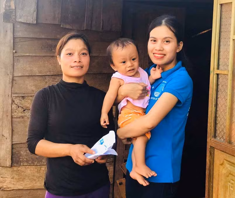 Chị Rơ Lan H’Thảo (bìa phải) nhận nuôi bé Rah Lan Trung đã khiến nhiều người cảm phục và xúc động. Ảnh: Trần Dung