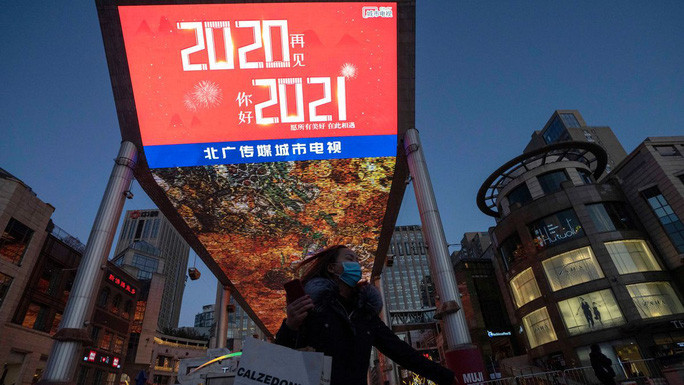  Một người dân đi ngang qua các khẩu hiệu mừng năm mới tại lối vào một trung tâm mua sắm ở thủ đô Bắc Kinh - Trung Quốc. Ảnh: AP