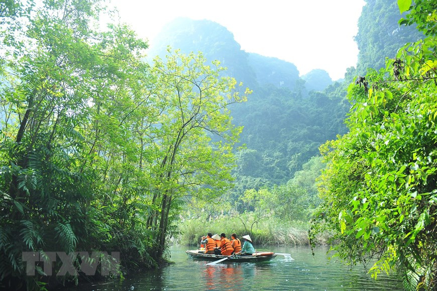 Du khách đi thuyền ngắm vẻ đẹp của quần thể danh thắng Tràng An. (Ảnh: Minh Đức/TTXVN)