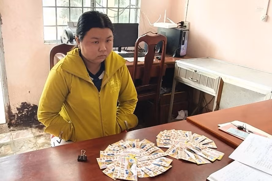 Đối tượng Nguyễn Thị Mai cùng tang vật vé số giả tại cơ quan công an. Ảnh công an cung cấp