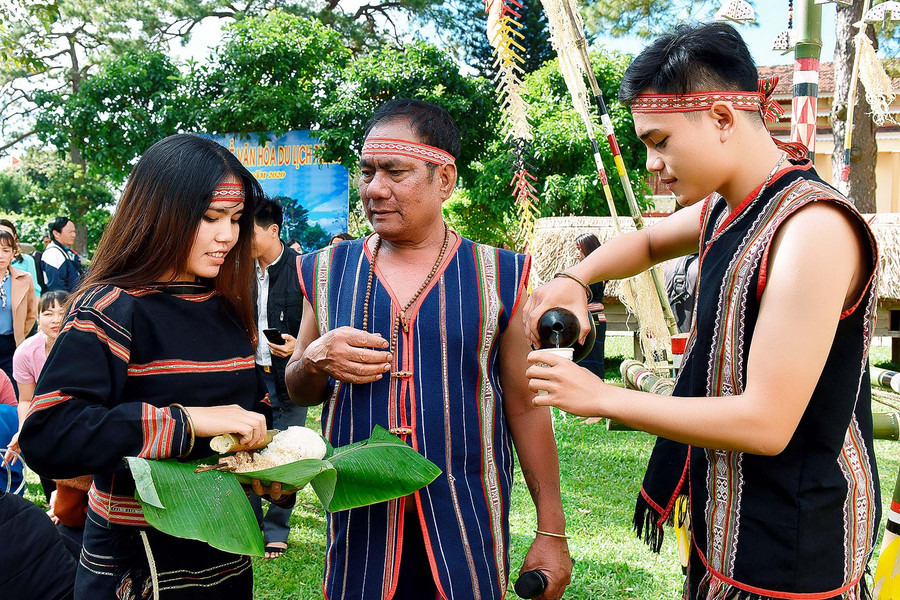 Đôi vợ chồng trẻ đứng cạnh nhau và mời rượu những người đã đến chung vui hạnh phúc với hai họ.
