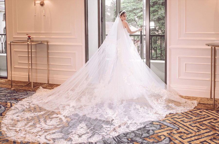 Người đẹp 20 tuổi trong mẫu váy cưới lộng lẫy. Phần cộc tay xuyên thấu dành cho người muốn khoe vòng một, đồng thời che khuyết điểm vai, bắp tay thô.