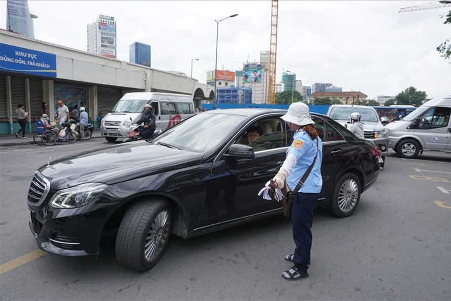  Nhân viên thu phí hướng dẫn cho xe ôtô vào đậu tại điểm đỗ xe ôtô có thu phí trên đường Phan Bội Châu (Q.1, TPHCM). Ảnh: MINH QUÂN