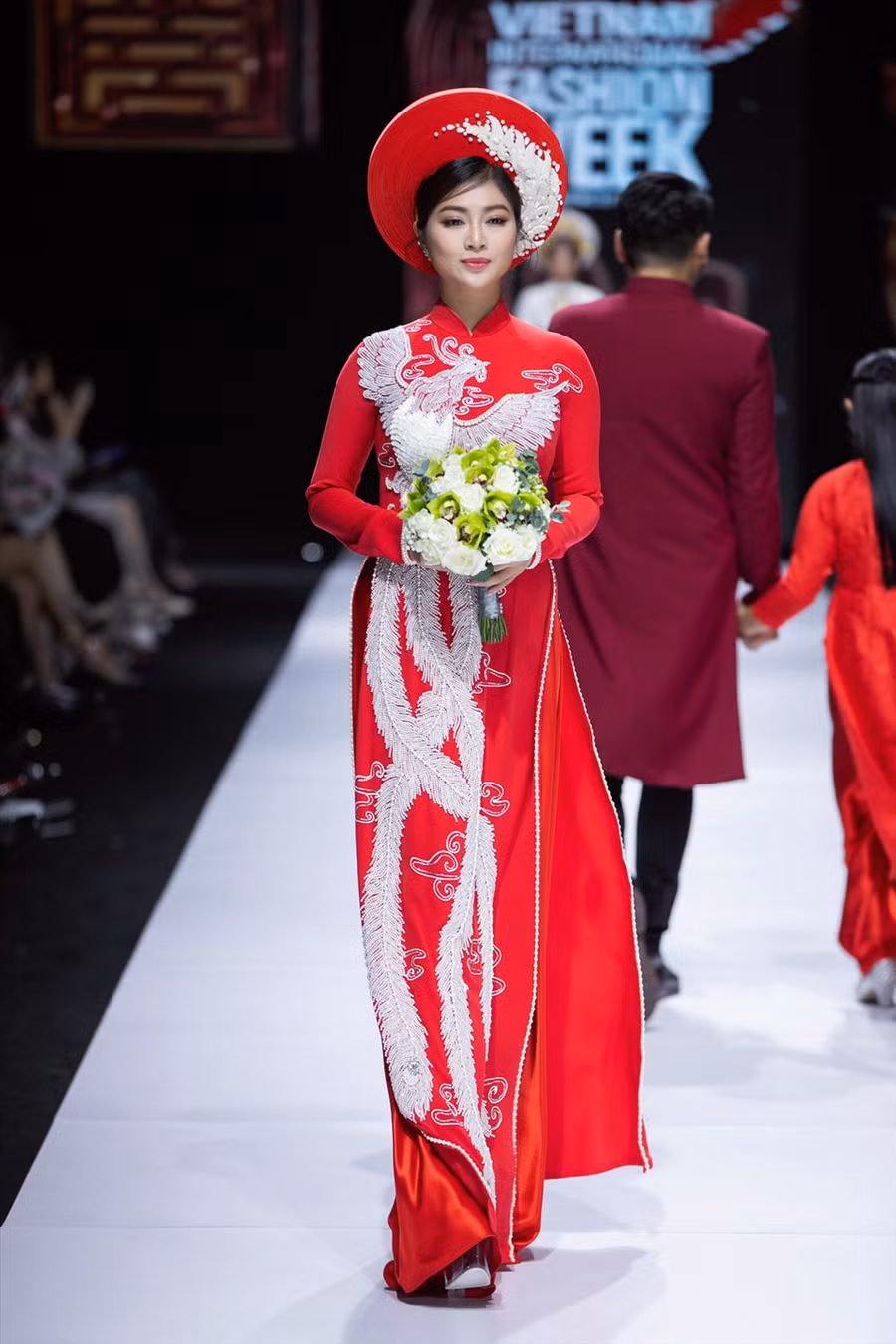 Bó hoa tulip trắng cùng những chiếc vòng cổ ngọc trai càng làm tôn thêm sự sang trọng của tà áo dài mà hai người mẫu đang khoác lên mình.