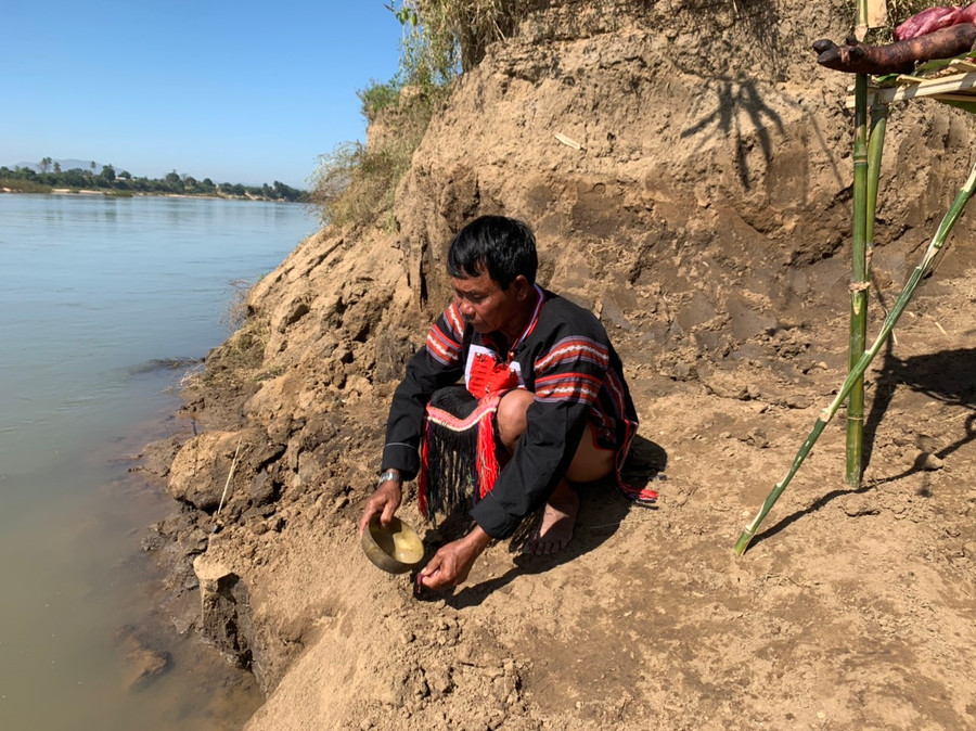 7.Thầy cúng rót đầy một cái chén rượu bằng đồng, cầm một miếng thịt, trút ra bến sông mời Giàng nước.