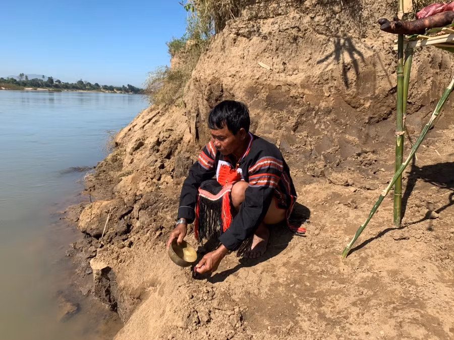 7.Thầy cúng rót đầy một cái chén rượu bằng đồng, cầm một miếng thịt, trút ra bến sông mời Giàng nước.