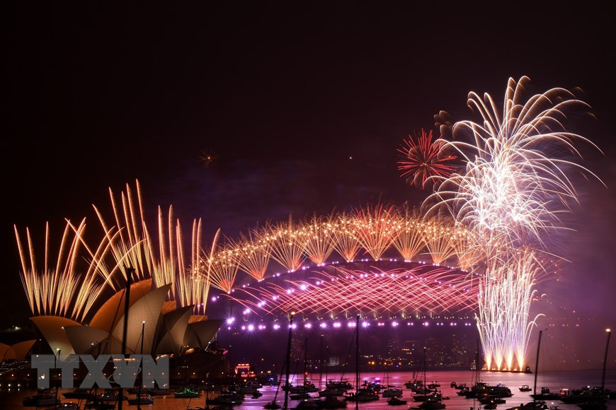 Pháo hoa mừng Năm mới rực rỡ trên cầu cảng Sydney. (Ảnh: AFP/TTXVN)